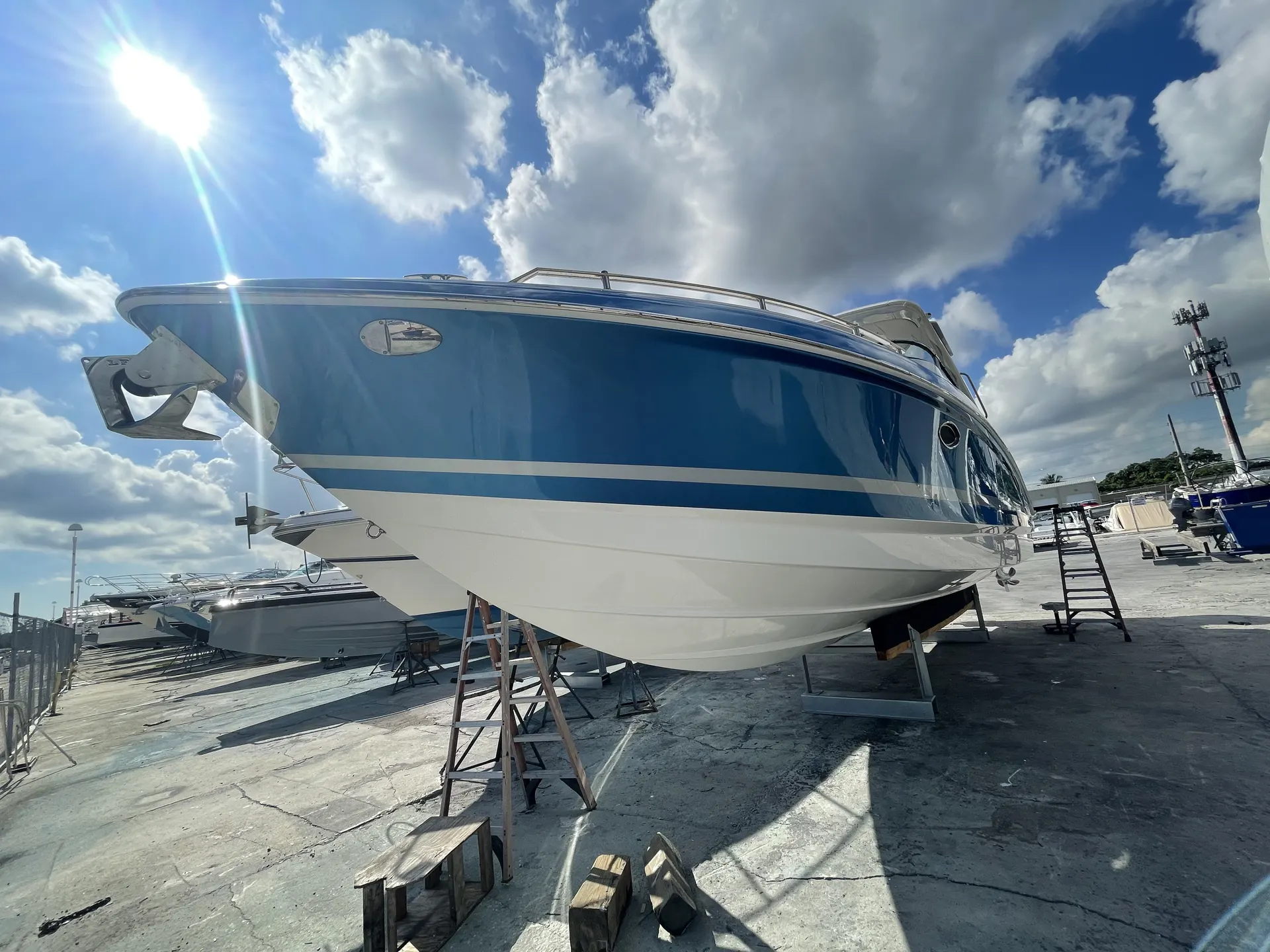 Bow and side of a refinished powerboat with a smooth gloss finish in dry dock
