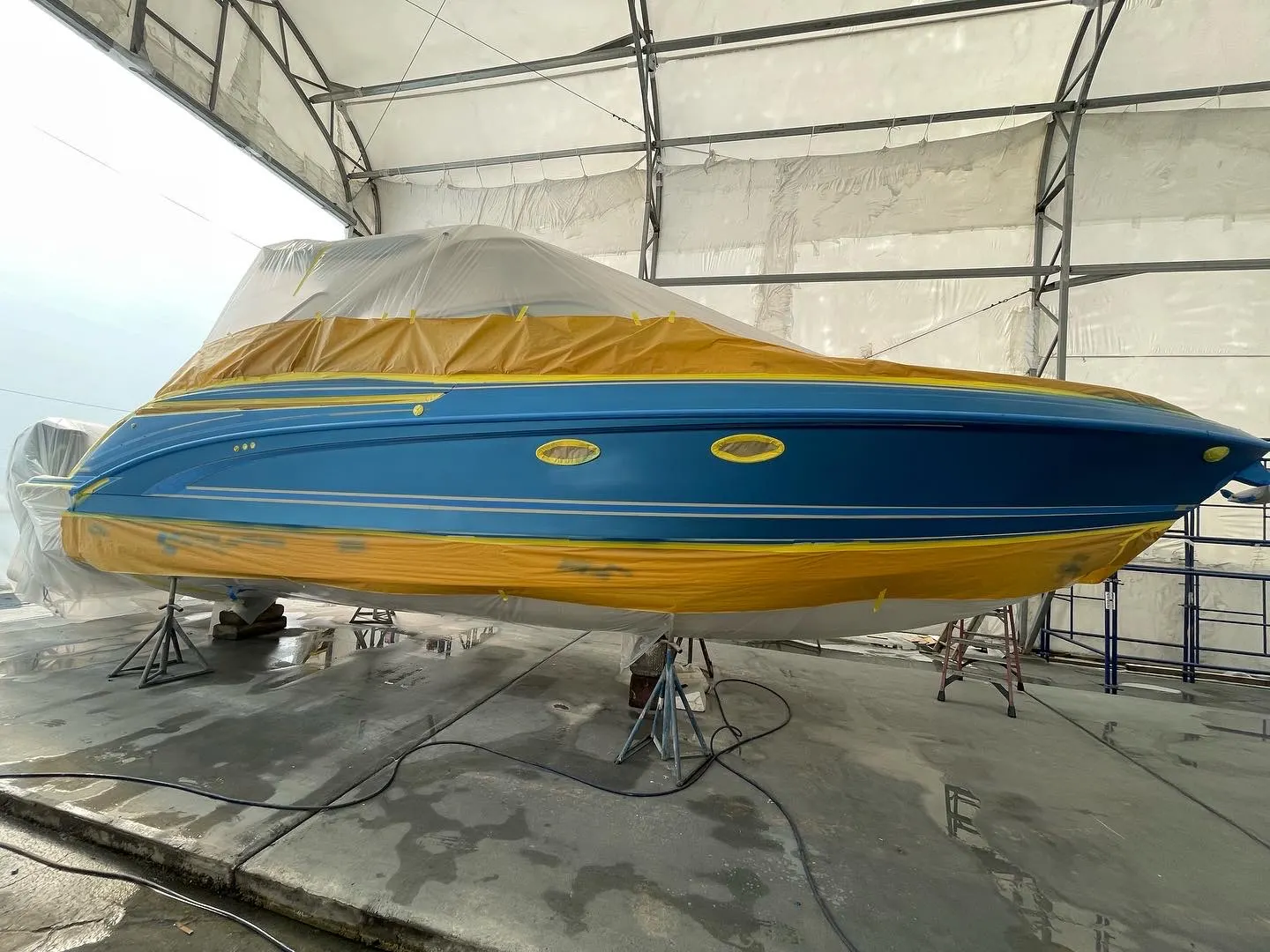 Hull portholes and fittings taped and masked during marine surface preparation